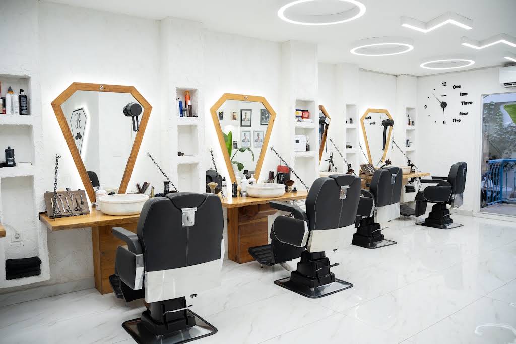 3E BarberShop'un beyaz ve ahşap detaylı güncel salon içi